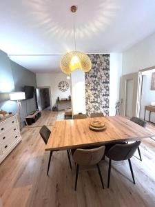 a dining room table with chairs and a chandelier at Le cocon d'Avallon - terrasse privé in Avallon