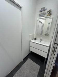 a bathroom with a white sink and a mirror at Le cocon d'Avallon - terrasse privé in Avallon