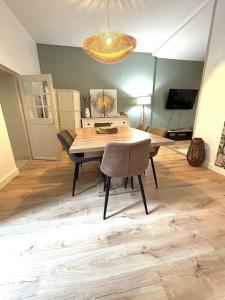a dining room with a wooden table and a chandelier at Le cocon d'Avallon - terrasse privé in Avallon +9 photos