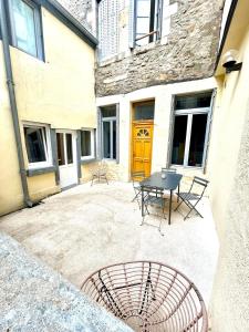 a patio with a table and chairs in front of a building at Le cocon d'Avallon - terrasse privé in Avallon