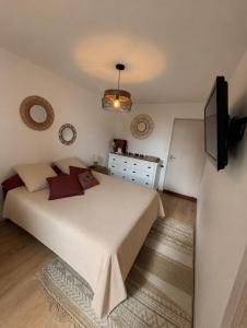 a bedroom with a large white bed and a television at Le cocon d'Avallon - terrasse privé in Avallon