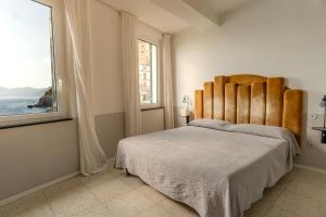 a bedroom with a large bed with a large window at Agave Room Rental in Riomaggiore
