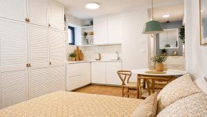 a kitchen with white cabinets and a table in a room at SEAESTA Cosy Sea Apartment in Koper