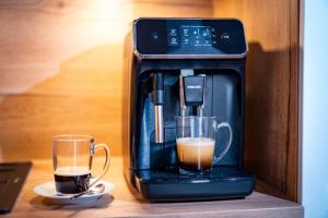 a coffee maker and two cups of coffee on a table at Ferienwohnungen Luxner in Gerlos