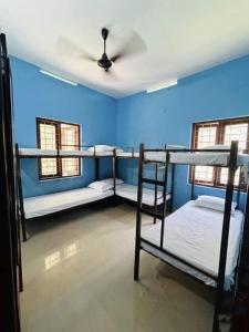a room with three bunk beds and blue walls at CK Enclave in Tripunittura