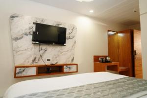 a bedroom with a bed and a tv on a wall at Hotel Bhagyalaxmi Luxury Inn in Ahmedabad +35 photos