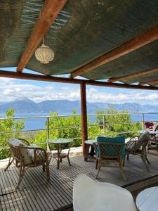 Eine Terrasse mit Stühlen und Tischen und Blick auf das Meer in der Unterkunft Arsinoe in Methana