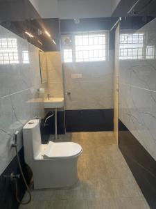 a bathroom with a toilet and a sink at Elixir Boarding & Lodging in Bangalore +23 photos