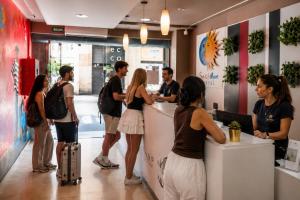 a group of people standing around a counter in a store at Sun & Moon Hostel in Barcelona