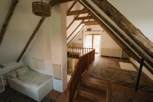 an attic room with a staircase and a couch at Baglyashegy Vendégház in Sümeg