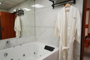 a bathroom with a robe hanging in front of a tub at Hotel Bhagyalaxmi Luxury Inn in Ahmedabad