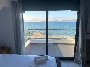 a bedroom with a bed and a view of the ocean at Althea Villas in Káto Ássos +16 photos