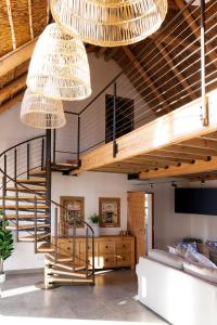 a living room with a staircase and two chandeliers at Bayview Bliss at Springerbaai Luxury Eco Villa with Ocean Views & Beach Access in Mossel Bay