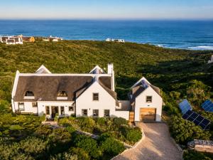 an aerial view of a house with the ocean in the background at Bayview Bliss at Springerbaai Luxury Eco Villa with Ocean Views & Beach Access in Mossel Bay