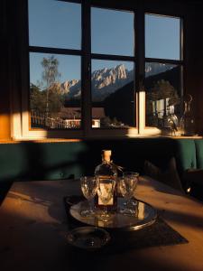 a table with two glasses and a bottle on it at Stern B&B & Suite Apartments in Nova Levante