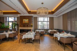 ein Esszimmer mit Tischen und Stühlen und einem Kronleuchter in der Unterkunft Hotel Mozart in Shkodra