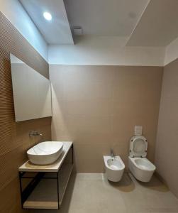 a bathroom with a sink and a toilet at Albergo Diomedee Rooms on the Beach in Rodi Garganico +36 photos