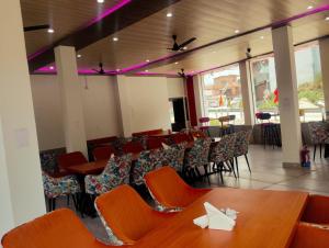 a dining room with tables and chairs and purple lights at cp residency in Karnaprayāg