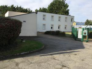 a white building with a fence in front of it at Be Myhôtel in Évreux