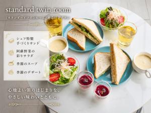 a table with two plates of sandwiches and a salad at フォレスタ阿蘇車帰 in Aso