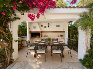 a patio with a table and chairs and flowers at AmetllaDeMar in Les tres Cales