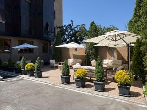a patio with tables and umbrellas and chairs and plants at Canyon Hills Hotel in Yerevan