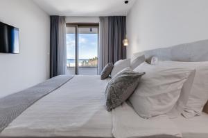 a bedroom with a white bed with pillows and a window at Villa Mare Zadar in Zadar +40 photos