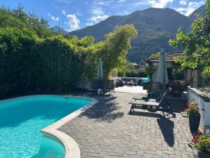 a backyard with a swimming pool and a table and chairs at Les Hortensias in Lantosque