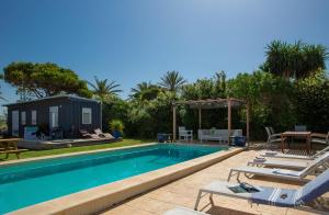 a swimming pool with chairs and a tiny house at Apartamentos Zahora 37 in Zahora