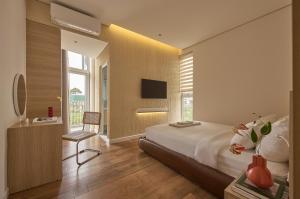a bedroom with a large bed and a television at Adela Hotel Dalat in Da Lat