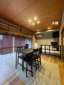 a dining room with a black table and chairs at コハクサカイミナト in Sakaiminato