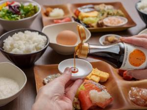 a person pouring sauce into a bowl of food at Premier Hotel-CABIN-Sapporo in Sapporo +70 photos