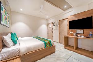 ein Schlafzimmer mit Bett und Flachbildfernseher in der Unterkunft Treebo MR Motel, 10 Mins To Airport in Mattanūr