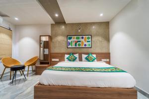 ein Schlafzimmer mit einem Bett, einem Tisch und Stühlen in der Unterkunft Treebo MR Motel, 10 Mins To Airport in Mattanūr + 26 Fotos