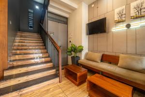 ein Wohnzimmer mit Sofa und Treppe in der Unterkunft Treebo MR Motel, 10 Mins To Airport in Mattanūr