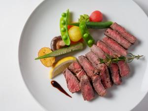 a plate of meat and vegetables on a white plate at Premier Hotel-CABIN-Sapporo in Sapporo