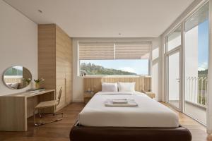 a bedroom with a bed and a desk and a mirror at Adela Hotel Dalat in Da Lat