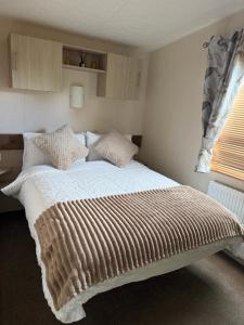 a bedroom with a large bed with white sheets and pillows at 20 The Green, Lilliardsedge in Jedburgh