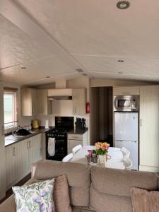 a kitchen and living room with a couch and a table at 20 The Green, Lilliardsedge in Jedburgh +35 photos