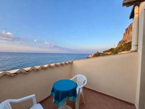 a balcony with a table and chairs and the ocean at La Casa Sulla Scogliera in Cefalù
