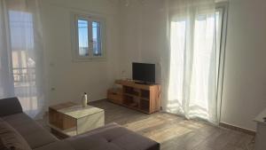 a living room with a couch and a tv at Moussa Erato in Agia Anna Naxos