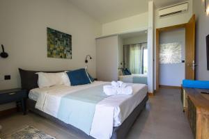 a bedroom with a large bed with towels on it at Luxury Beachfront Apartment in Pereybere