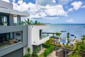 a view of the ocean from the balcony of a house at Luxury Beachfront Apartment in Pereybere