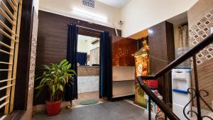 a hallway with a door to a kitchen with a plant at Ashok Nandini Guest House in Bhubaneshwar