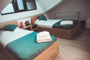 ein Schlafzimmer mit zwei Betten, auf denen Handtücher liegen in der Unterkunft Casa Ducu in Călimăneşti + 48 Fotos