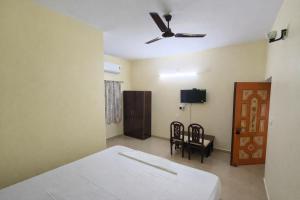 a bedroom with a bed and a ceiling fan at Ashok Nandini Guest House in Bhubaneshwar