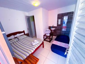 a small bedroom with a bed and a sink at Suítes Jacumã in Conde