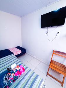 a bedroom with a bed and a tv on the wall at Suítes Jacumã in Conde +12 photos
