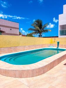 a swimming pool in front of a wall at Suítes Jacumã in Conde