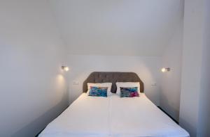 a bed in a room with two pillows on it at Domki Venus z basenem in Ustronie Morskie +19 photos